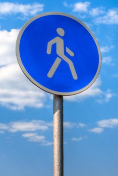 pedestrian zone sign against blue sky with clouds