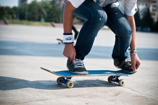 young skater perfoming stunt on his blue board