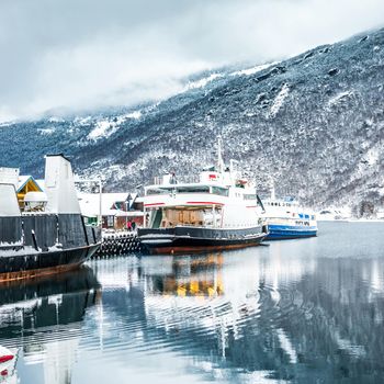 The ships and boats on the mooring in the Norwegian fjords in the winter