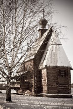 old wooden church in the birch tree forest in the winter