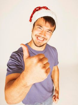 funy exotical asian Santa claus in new years red hat smiling on white background