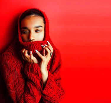 young pretty indian girl in red sweater posing emotional, fashion hipster teenage, lifestyle people concept closeup