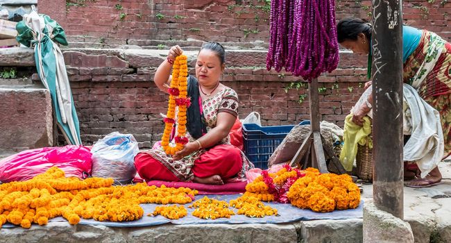 KATHMANDU, - OCTOBER 05: People sell flower necklaces next to Kathmandu Durbar Square in Kathmandu, Nepal, October 05, 2017