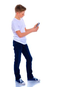 A small boy of school age uses a mobile phone. The concept of digital technology, communication between people. Isolated on white background.