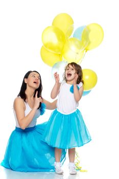 Beautiful mother and daughter in long blue skirts, along with balloons.They rejoice in the holiday.Isolated on white background.