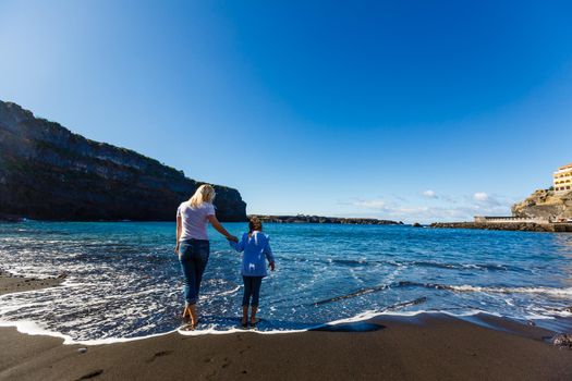 Family holiday on Tenerife, Spain. Mother with children outdoors on ocean. Portrait travel tourists - mom with kids. Positive human emotions, active lifestyles. Happy young family on sea beach