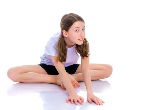 A girl gymnast performs an acrobatic element on the floor. The concept of childhood, sport, healthy lifestyle. Isolated on white background.