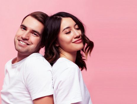 young cheerful caucasian couple together having fun on pink background, guy ang girl modern relationship, lifestyle people concept close up