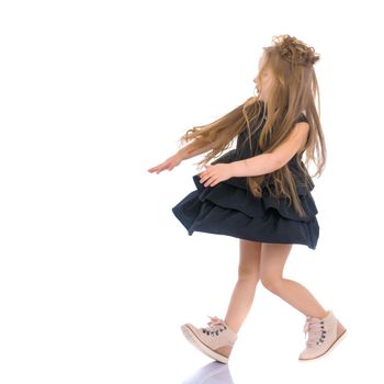 Beautiful little girl is having fun dancing in the studio on a white background. The concept of a school of dance, happy people. Isolated.