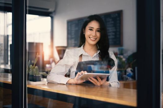 At her cafe, the business owner or barista is taking orders from customers.