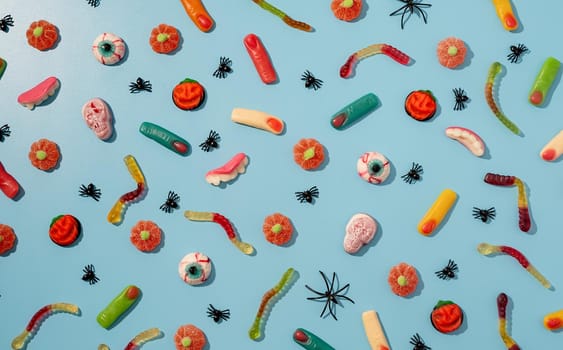 Halloween concept. Colorful sweets for Halloween party on blue background, top view flat lay