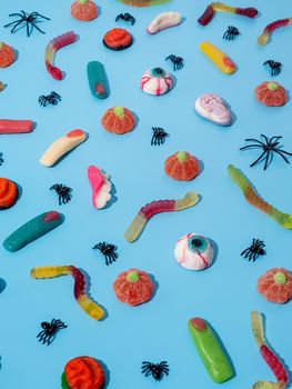 Halloween concept. Colorful sweets for Halloween party on blue background, top view flat lay