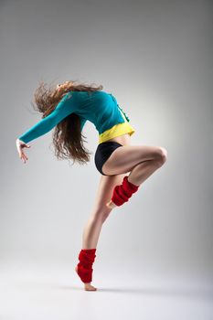 Modern style dancer posing on a studio grey background