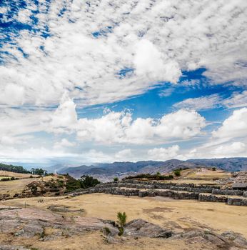 Ancient ruins of castle Saksaywaman on background of beatiful blue sky and large fluffy clouds