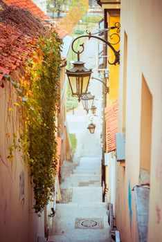 Narrow street with stairs and lamps in the Old town of Warsaw, Poland