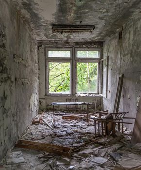 abandoned school study with debris and broken furniture in Pripyat