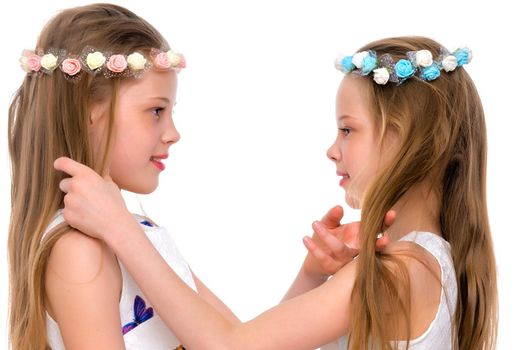 Two cute little girls close-up, in the studio on a white background. The concept of a happy childhood, Beauty and fashion. Isolated.