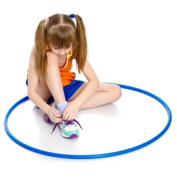 The little girl puts on her shoes. The concept of beauty and fashion, happy childhood. Isolated on white background.