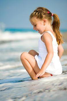 sitting little girl on tropical beach vacation