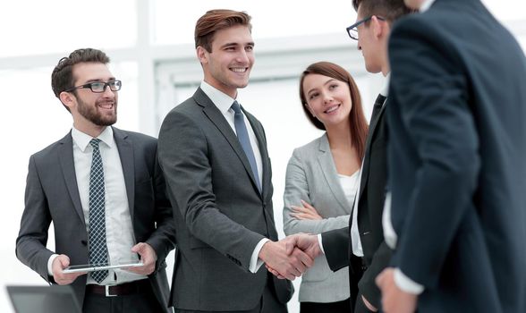 colleagues shaking hands in office.