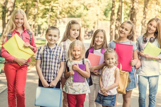 group of children with school backpacks in the park