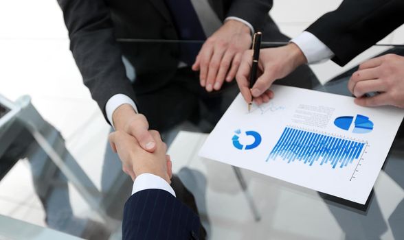 handshake of financial partners at the Desk.
