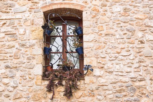 Design, architecture and exterior concept - Beautiful wrought-iron grille in the window on stone wall.