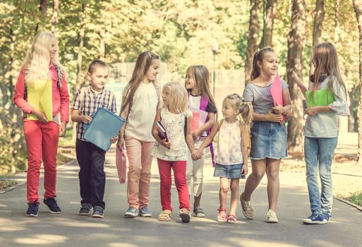 group of children with school backpacks in the park