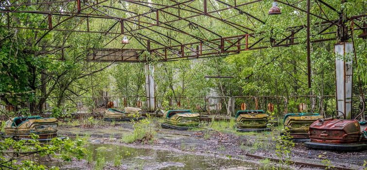 playground with rusty cars in abandoned Pripyat park