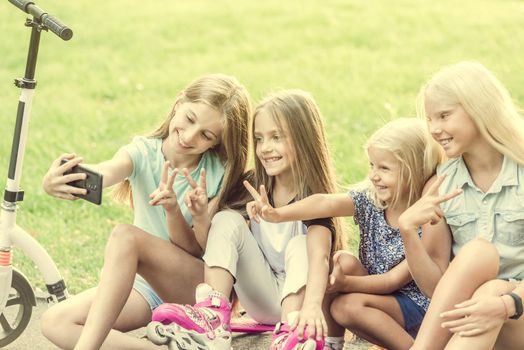 Teenage girls making selfie outdoors. Happy friends in the park on a sunny day. Happy friendship concept