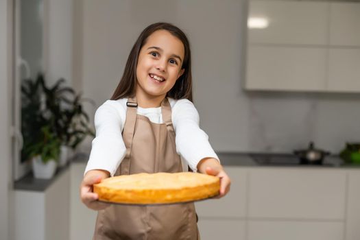little girl showing apple pie that she baked
