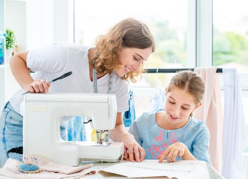 Tailor is teaching student at workshop