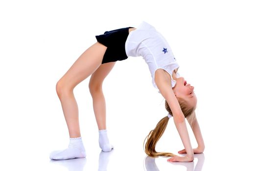 A girl gymnast performs an acrobatic element on the floor. The concept of childhood, sport, healthy lifestyle. Isolated on white background.