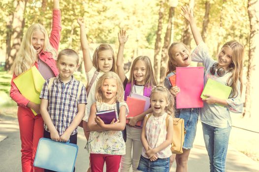 group of children with school backpacks in the park