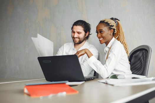 Handsome man in a white shirt. African woman with partner. Guy with a laptop.