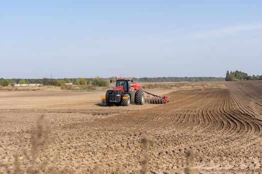 Tractor cultivating soil and preparing a field for planting