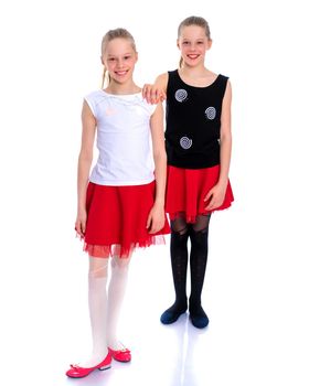 Two cute little girls in full growth, in the studio on a white background. The concept of a happy childhood, Beauty and fashion. Isolated.