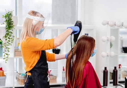 Hairdresser care about long hair of client wearing masks. Hairstyle in coronavirus time