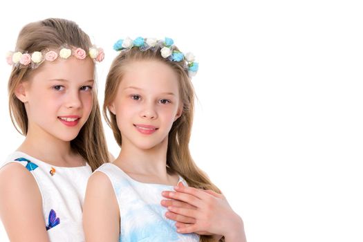 Two cute little girls close-up, in the studio on a white background. The concept of a happy childhood, Beauty and fashion. Isolated.