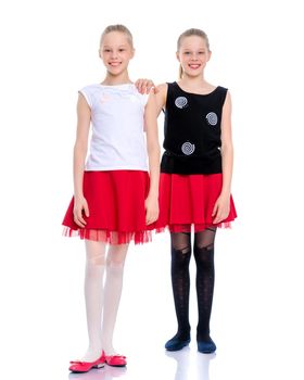 Two cute little girls in full growth, in the studio on a white background. The concept of a happy childhood, Beauty and fashion. Isolated.