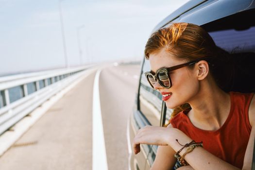 pretty woman in sunglasses rides in a travel car. High quality photo