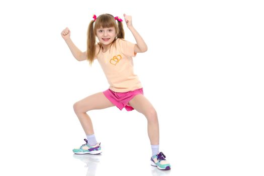 A nice little girl is performing gymnastic exercises. Concept of a healthy lifestyle, sport and fitness. Isolated on white background.