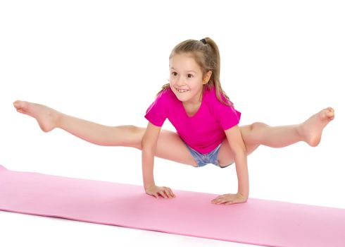 A girl gymnast performs an acrobatic element on the floor. The concept of childhood, sport, healthy lifestyle. Isolated on white background.