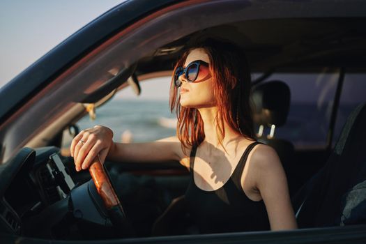 cheerful woman in sunglasses driving a car trip travel. High quality photo