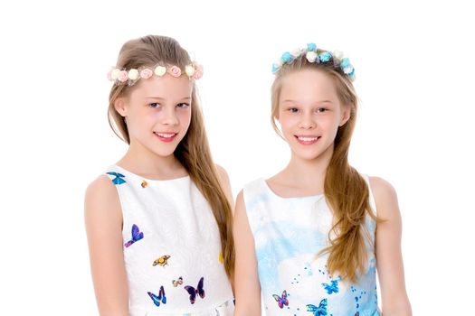 Two cute little girls close-up, in the studio on a white background. The concept of a happy childhood, Beauty and fashion. Isolated.