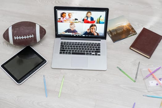 Open laptop with football or rugby ball on the floor, video chat