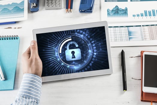 close-up, male hands with tablet. Businessman working at the table in office. computer security concept