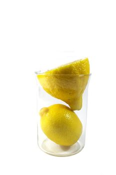 two parts of yellow ripe lemon in the glass on white background