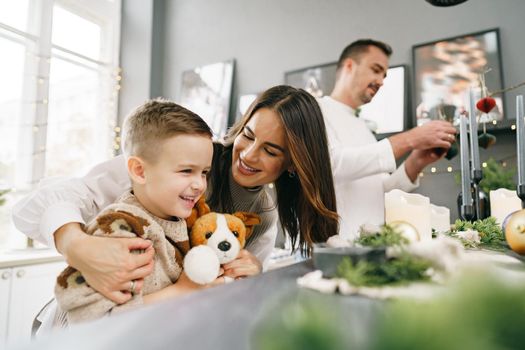 A portrait of happy family in the kitchen decorated for Christmas holidays