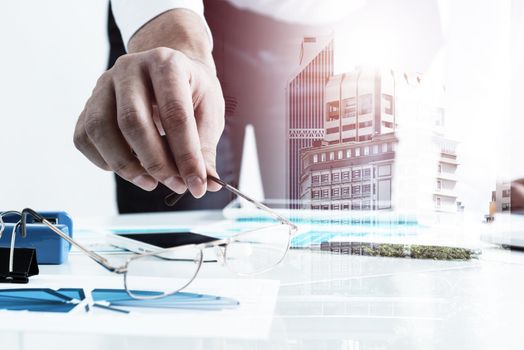 Businessman standing near office desk and analyzing financial charts. Successful corporate manager in business suit and tie. Close-up man hand with analytics. Entrepreneurship double exposure concept